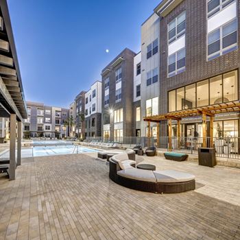 A modern outdoor pool area with a wooden deck and lounge chairs.